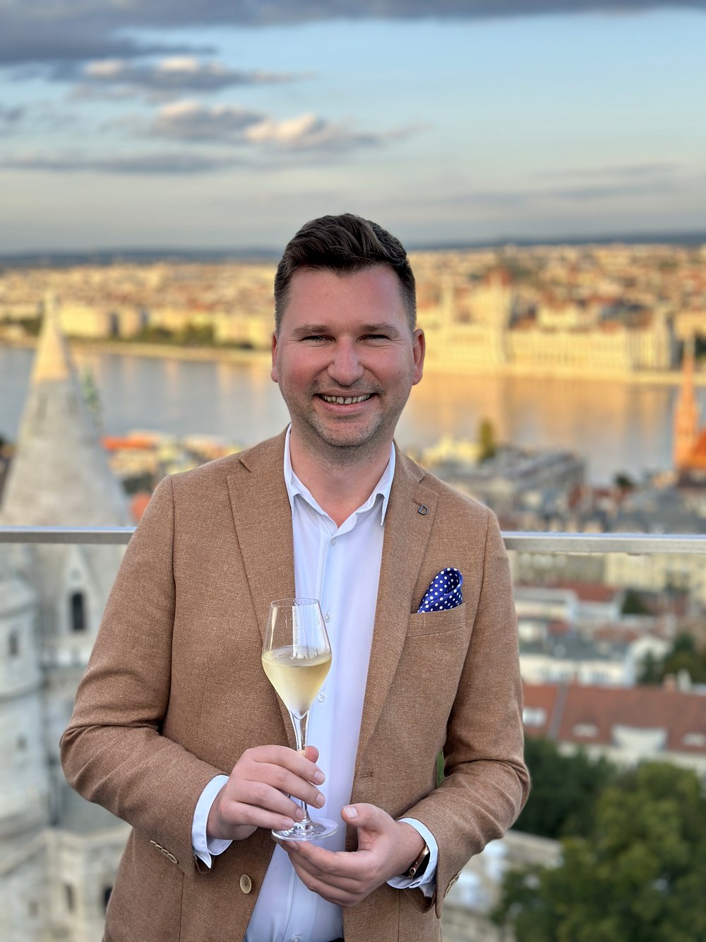 Glass of white wine above the Danube at golden hour, Fisherman's Bastion