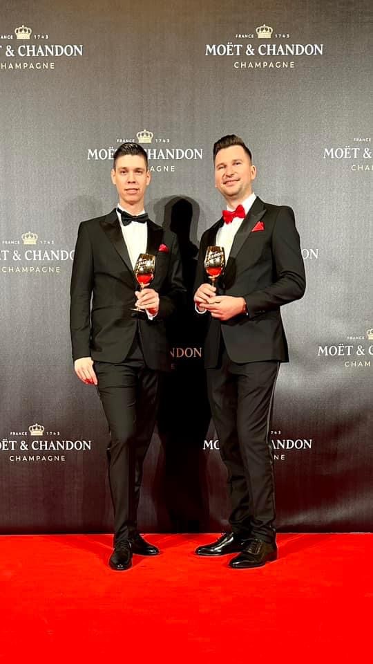 János Kopasz and Máté Hajdu in black tie before the full Moët & Chandon backdrop at the Hungarian State Opera